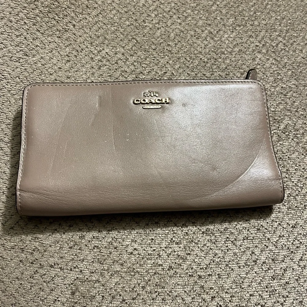 Coach wallet. Has some wear marks and wrinkles on outside of wallet.